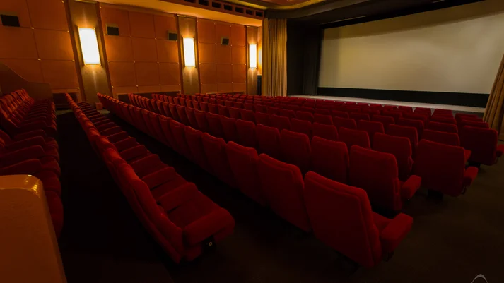 Kinosaal mit roten Kinosesseln - Blick auf die Leinwand